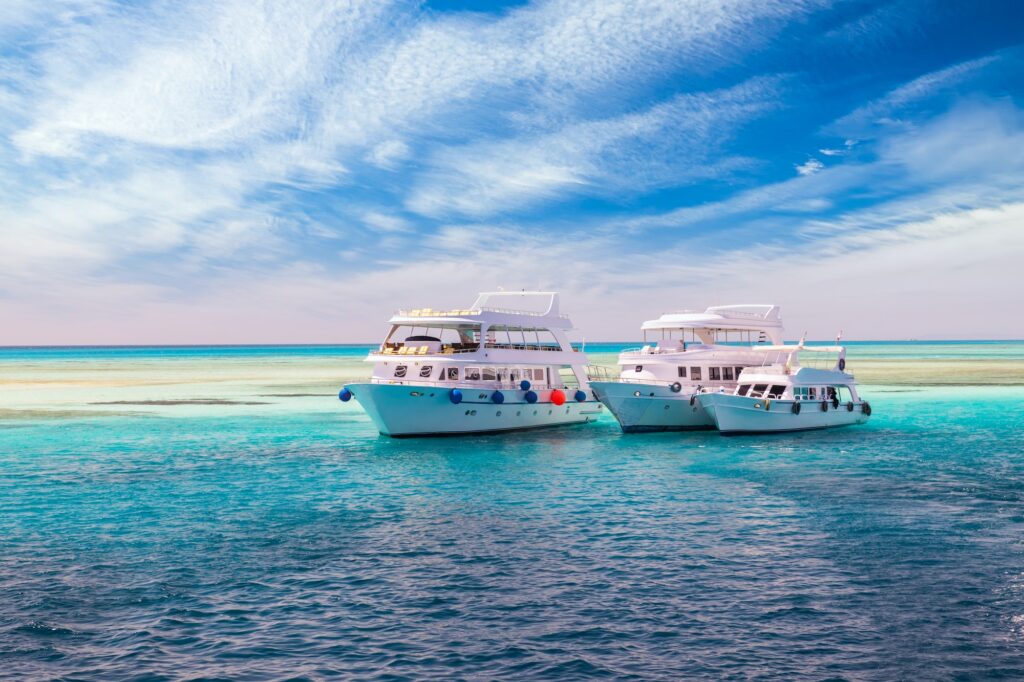 Cruise yacht bow in clear water near a coral reef. Red Sea, Egypt